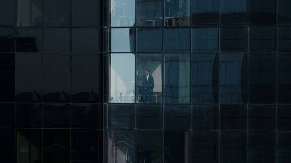 鸟瞰图镜头:从外面到办公大楼与商人工作和看窗外美丽的飞行放大拍摄的金融商业区摩天大楼