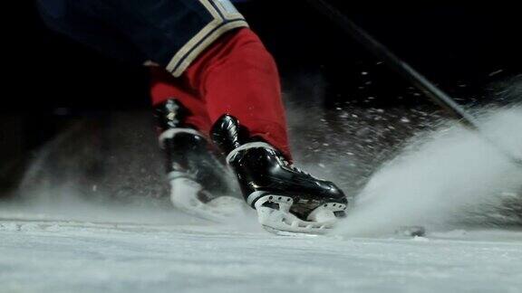 冰球的特写是在冰上的慢镜头中冰球运动员停下来雪花飞进镜头他拿起冰球棒