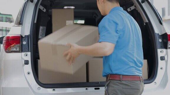 上门交付快递员卸货他的运输货车和包裹在纸板箱和检查库存包裹邮寄给客户之前