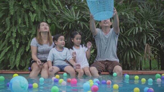 一家人在泳池边玩彩色球慢镜头