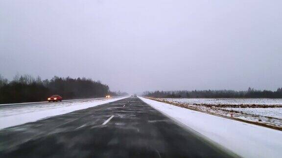 在可怕的多雪多风的天气里在高速公路上开车透过挡风玻璃的视野-驾驶员视角移动视频