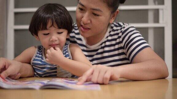 亚洲男孩和妈妈一起看书