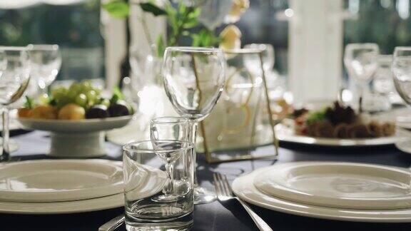 玻璃杯和盘子放在一张美丽的节日餐桌上盘子洗干净了正在等客人