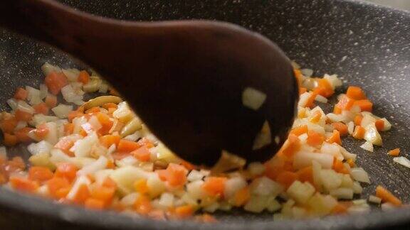 在煎锅中翻炒洋葱、胡萝卜、大蒜