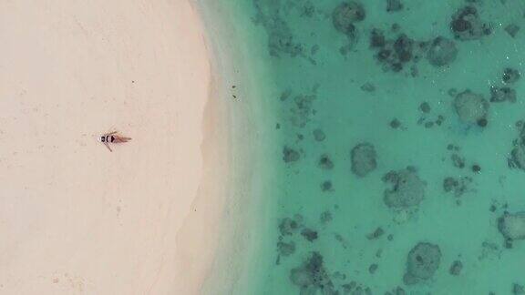 女人躺在沙滩上的鸟瞰图