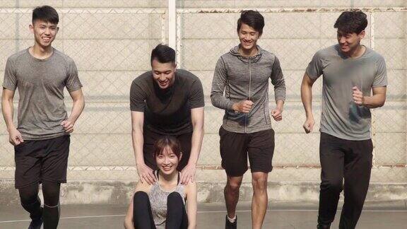 五个年轻的亚洲成年人在户外篮球场上玩耍