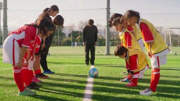 女足队员或女足队员和教练在开始练习前互相尊重并鞠躬