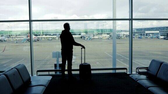 一位中年男子在机场窗口挥手道别旅行概念