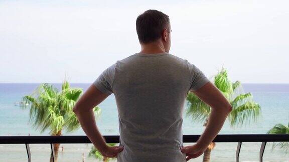 男人走到阳台上在阳台上欣赏风景男度假看地中海