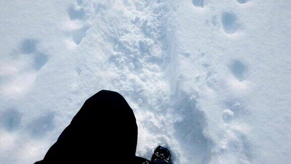 一个登山运动员穿着靴子在雪山上行走