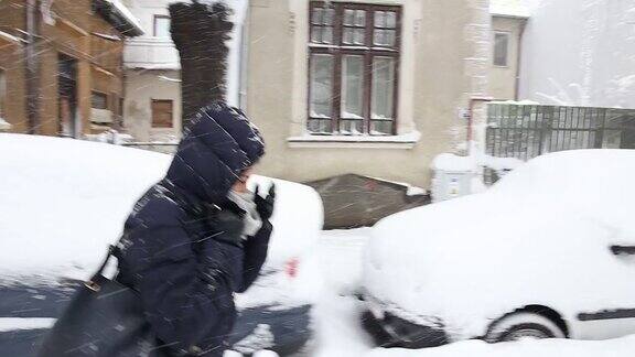 年轻女子走在下雪的街上