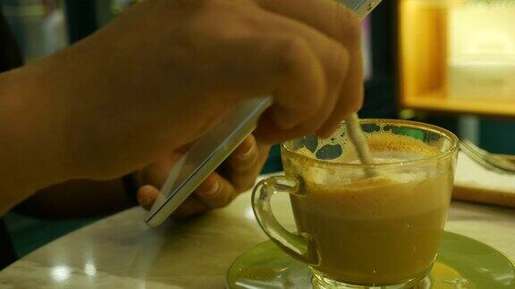 人类的手在咖啡店使用手机