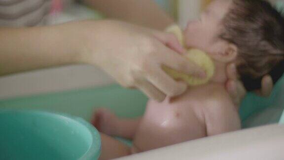 近距离亚洲可爱的新生儿男孩洗澡2-3个月与母亲