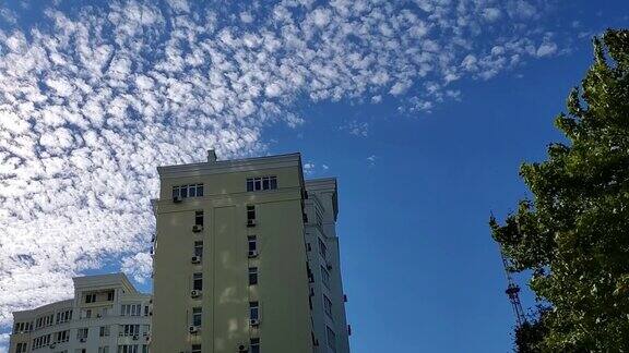 超断层建筑屋顶和蓝色天空中白色蓬松的积云时间流逝cloudscape