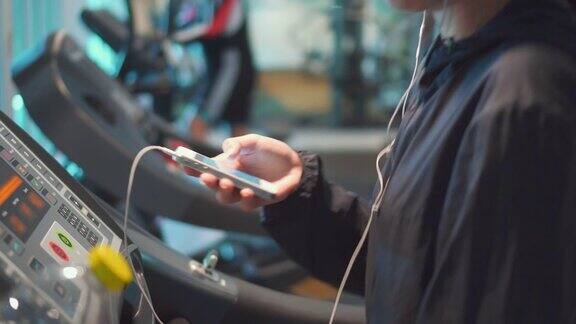 年轻女性在健身房使用智能手机