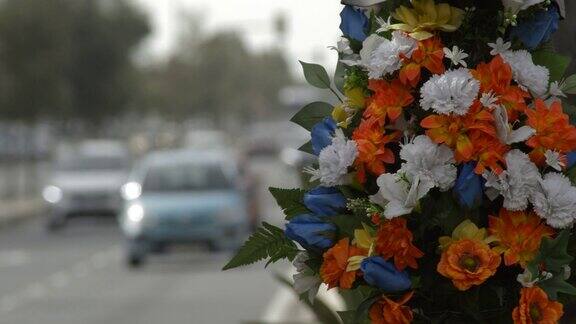 路灯上的鲜花纪念一场交通事故和路上的汽车