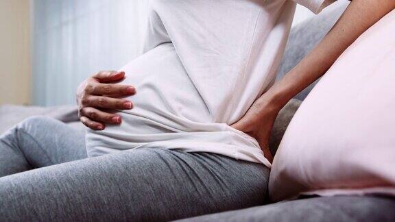 孕妇的手按摩她的背部疼痛