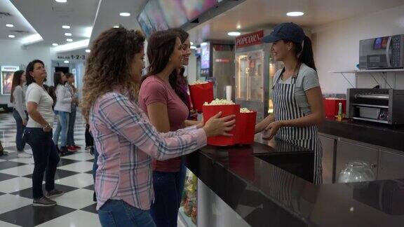 一群开心的女性朋友在电影院的小卖部买零食