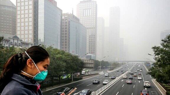 中国北京2014年10月25日:中国北京在恶劣的天气里一位戴口罩的女士在国贸CBD的建筑上拍照