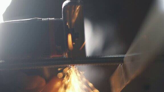 工业工人在工厂工作时使用角磨床切割钢材切割金属的火花击中了相机人在工厂工作在工业中使用工具缓慢的运动