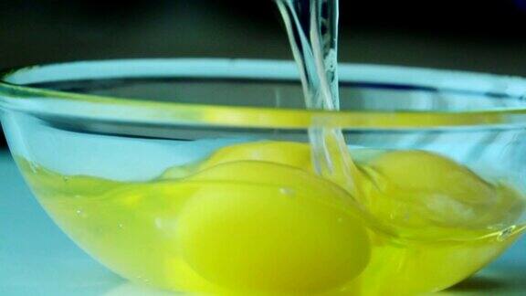 在玻璃碗里打鸡蛋新鲜的有机鸡蛋掉进碗里