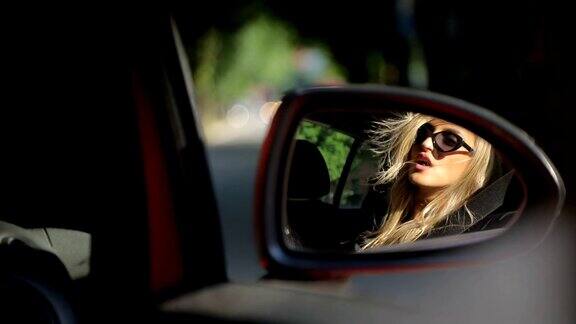 从车的后视镜中映出的漂亮女人