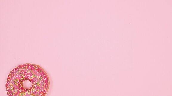 移动出现和消失的草莓甜甜圈在粉彩粉红色的背景停止运动食品平躺