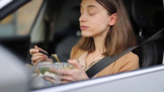 女商人坐在驾驶座上吃沙拉