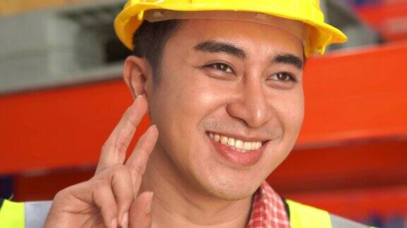 在仓库工作的员工的肖像打招呼手势胜利手势