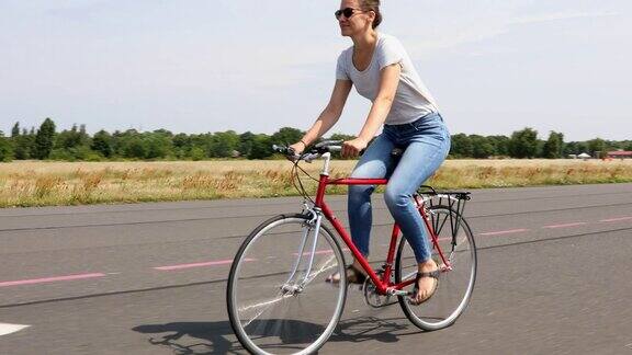 快乐的年轻女子享受自行车的自由