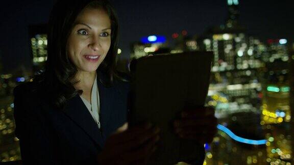 拉丁美洲女商人晚上在屋顶上进行视频通话
