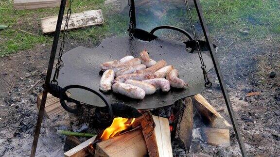 美味多汁的香肠在火上煎锅烧烤