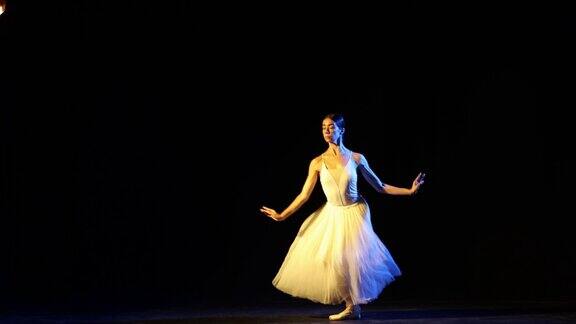 芭蕾舞演员在黑暗的剧院舞台上跳舞