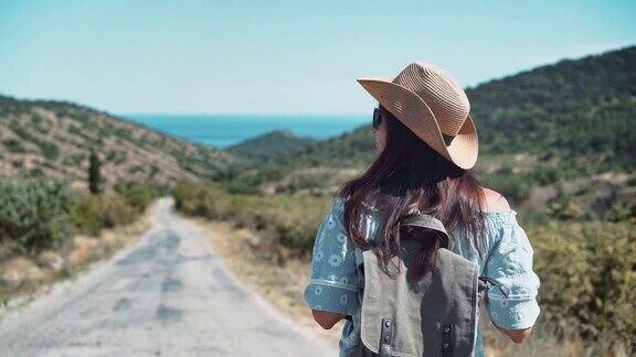 女背包客徒步走在山间小路上