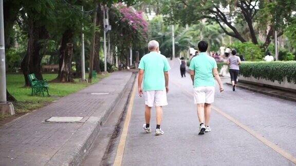 快乐的亚洲老年夫妇沿着公园散步锻炼抽象热爱健康和自然