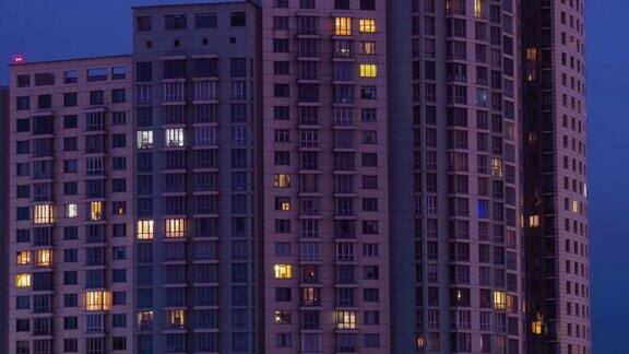 生活公寓大楼窗户在黄昏到夜晚的时间推移-正面的观点
