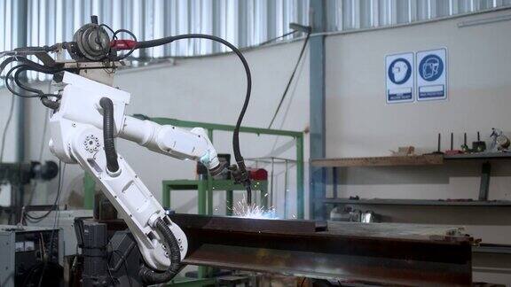 工业4.0概念现代自动化机器人焊接臂机床焊接金属管道和钢板与明亮的火花和烟雾在生产工厂车间的事实背景