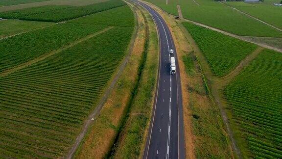 高角度视野双拖车卡车在高速公路通过农业领域