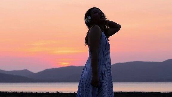 亚洲女人在海边放松在日落时间孤独的感觉