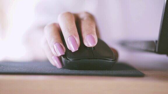 女人用无线鼠标在家里工作电脑笔记本电脑