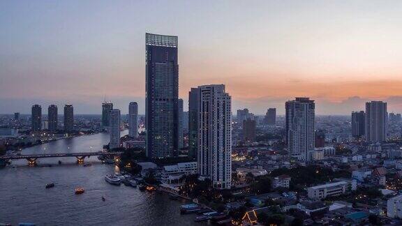 从白天到晚上4k时间的现代建筑在河边在泰国曼谷的桥上交通