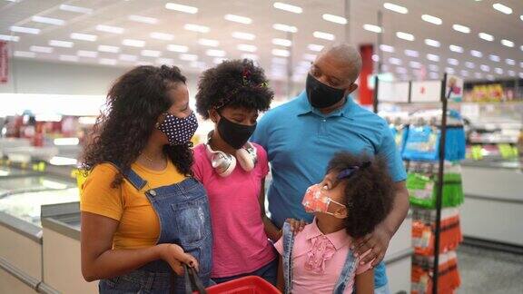 一个家庭使用口罩在超市的肖像