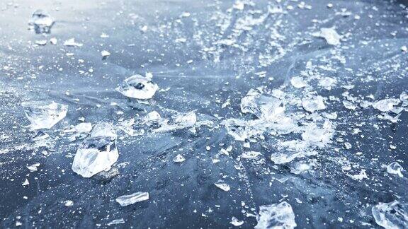 戴手套的人在冰上打碎冰缓慢的运动镜头移到了冰的后面一块美丽的冰在冰的周围裂开有神奇的裂缝冰冻水的颗粒