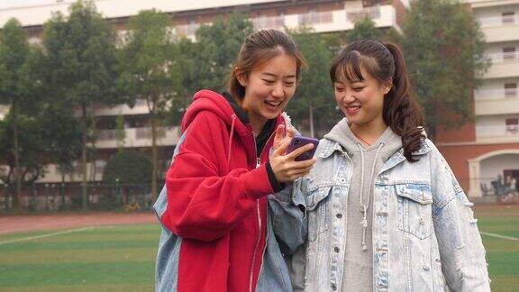 两个快乐的亚洲女孩在校园里聊天
