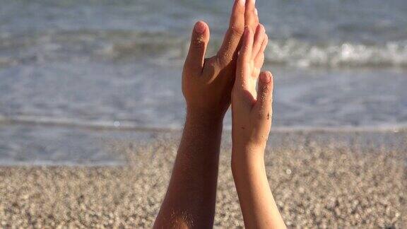 温柔的触碰恋人的手嬉戏手指的触碰近处沙滩大海挥手