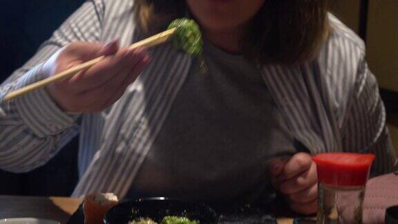 女人用木筷子吃海草沙拉特写镜头中国筷子夹着海草沙拉
