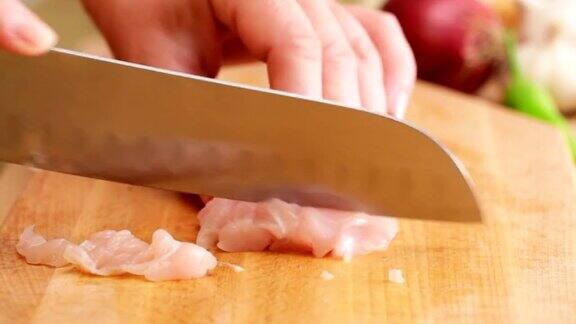 厨师用三德厨刀将鸡胸肉切成薄片