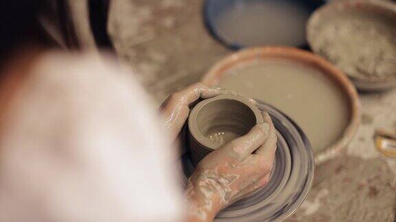 一个制陶女工在制陶轮上制陶特写特写慢镜头