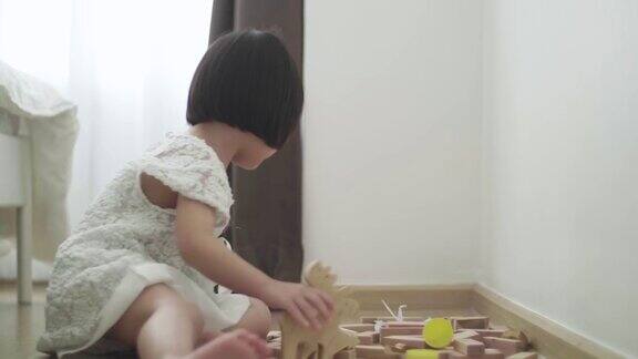 小女孩在地板上玩木制玩具