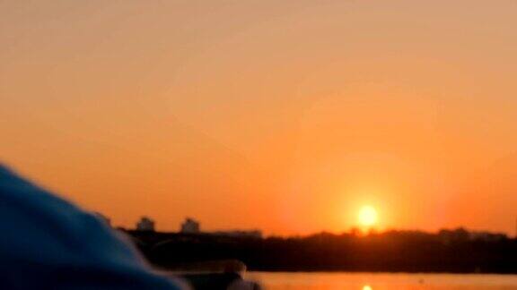 一名男子在城市码头上用智能手机拍摄日落